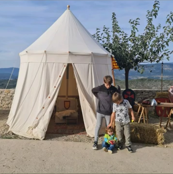 Los niños junto a una tienda del campamento medieval de Culla