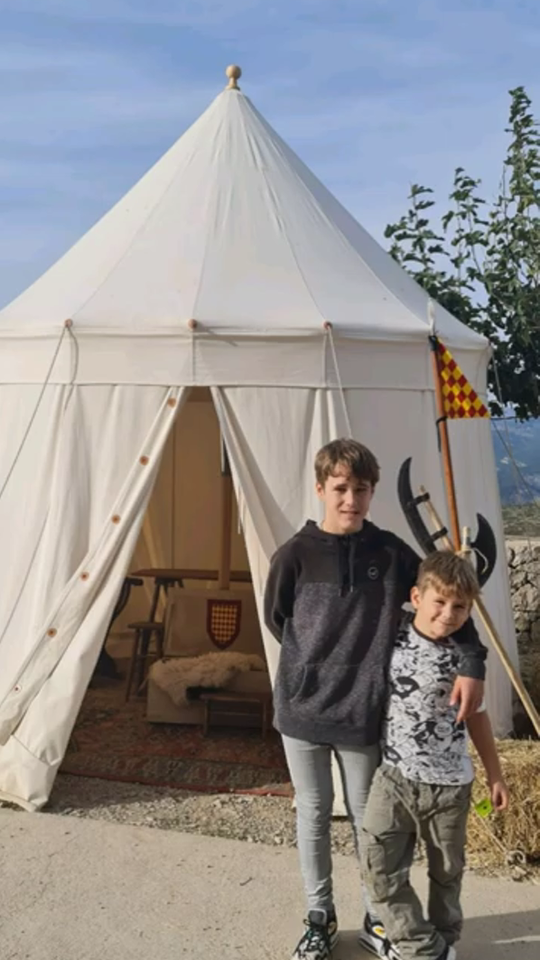 Dos niños frente a una tienda medieval en Culla