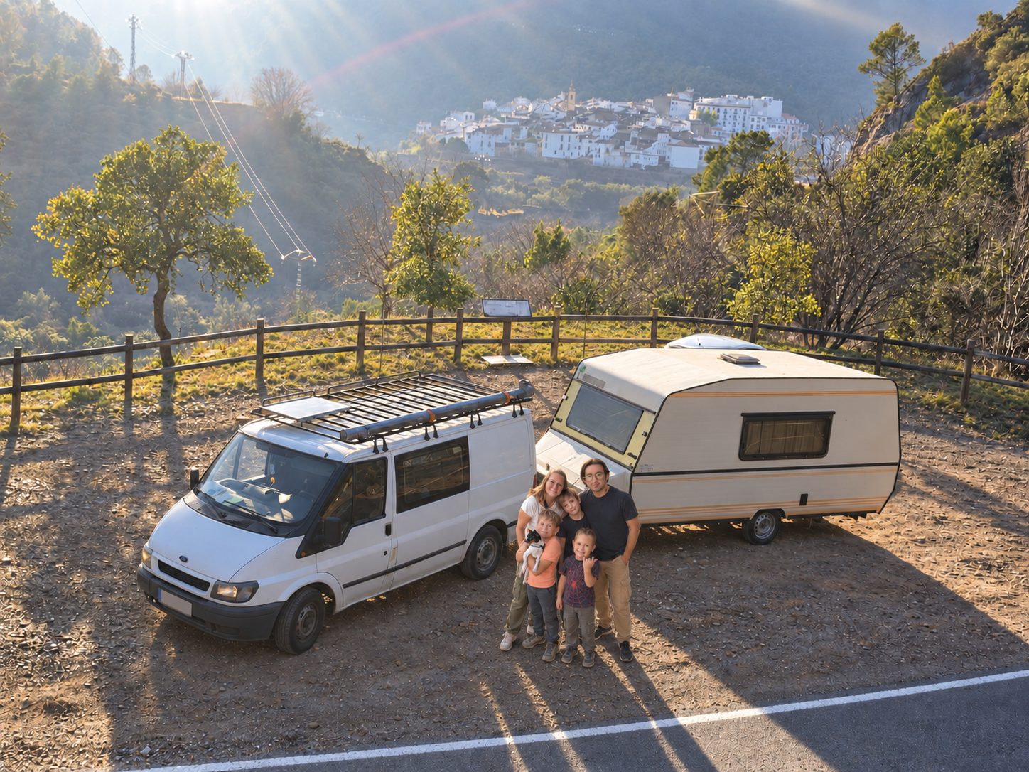 La familia de 5enruta junto a su furgoneta y caravana en un mirador de montaña